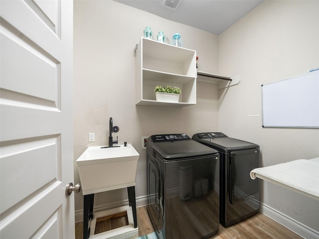 washroom with visible vents, light wood-type flooring, laundry area, independent washer and dryer, and baseboards