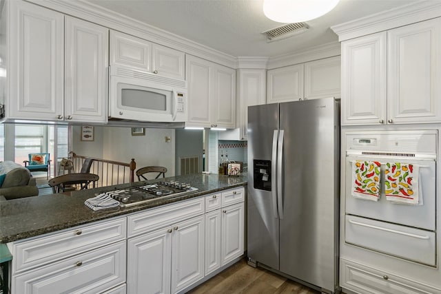 kitchen with white cabinetry, a warming drawer, dark wood-style floors, and stainless steel appliances