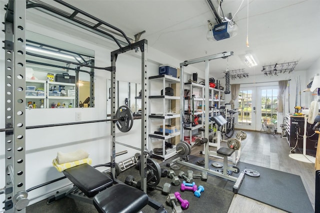 exercise room with wood finished floors, french doors, and a garage