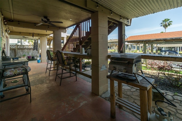 view of patio featuring area for grilling, stairway, a ceiling fan, and fence