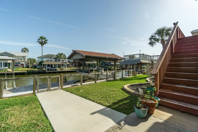 view of dock with a water view, stairs, a lawn, boat lift, and a gate