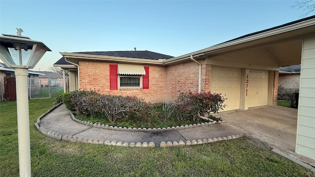 view of property exterior with brick siding, fence, a lawn, a garage, and driveway