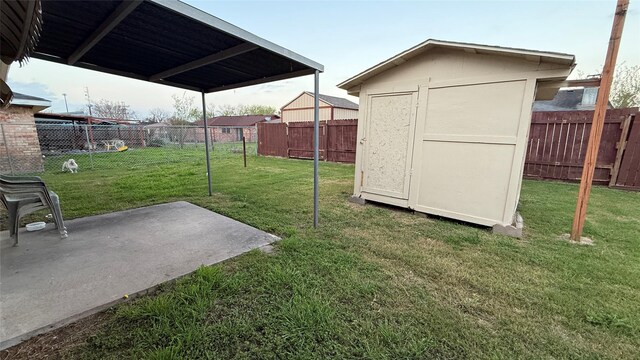 view of yard featuring a storage unit, a fenced backyard, an outdoor structure, and a patio area