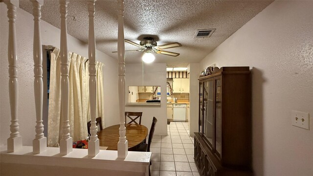 unfurnished dining area featuring light tile patterned floors, visible vents, a textured ceiling, and a ceiling fan