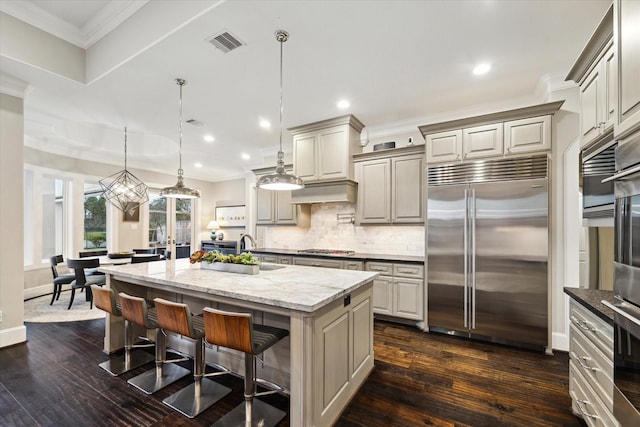 kitchen featuring visible vents, ornamental molding, a sink, tasteful backsplash, and stainless steel appliances