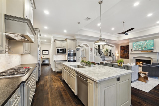 kitchen featuring a sink, stainless steel appliances, custom exhaust hood, and cream cabinets