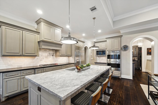 kitchen featuring gray cabinets, visible vents, arched walkways, and built in appliances