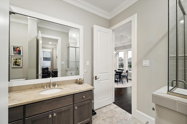 bathroom with crown molding, baseboards, ensuite bathroom, wood finished floors, and vanity