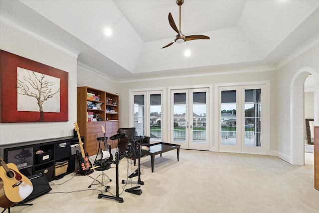 interior space with a healthy amount of sunlight, french doors, a tray ceiling, and a ceiling fan