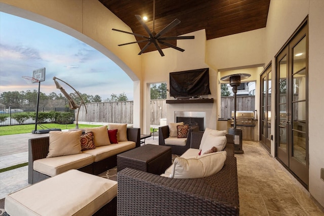 view of patio with an outdoor living space with a fireplace, a grill, ceiling fan, and fence