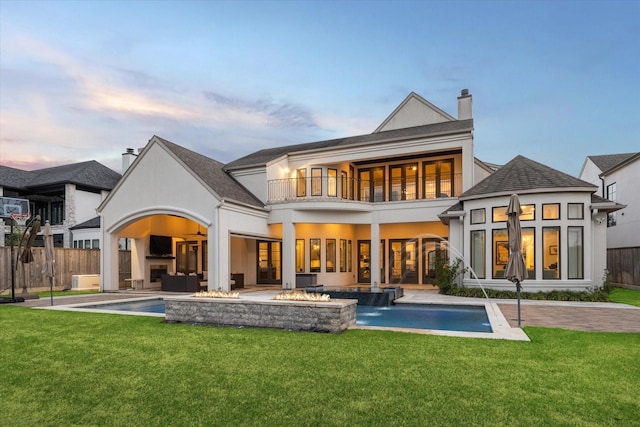 back of house featuring a yard, an outdoor hangout area, a balcony, and fence