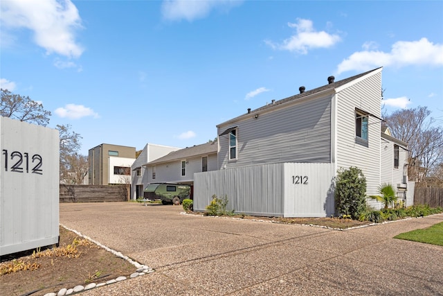 back of property with a residential view and fence