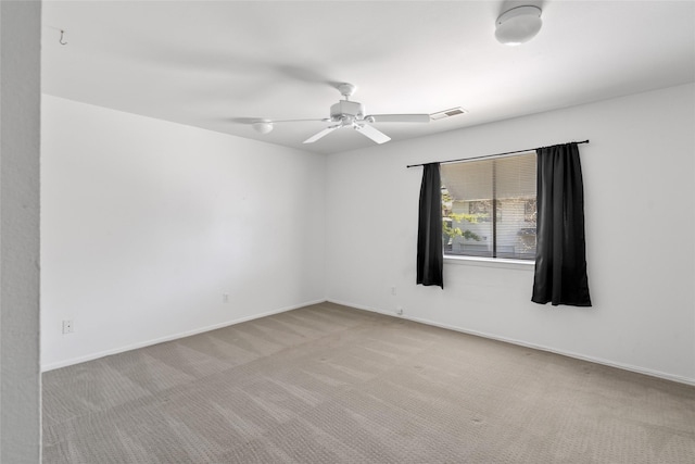 unfurnished room with carpet floors, visible vents, baseboards, and a ceiling fan