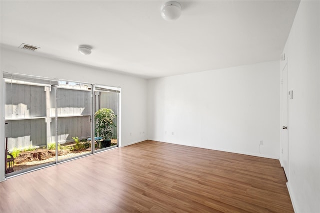 unfurnished room featuring visible vents and wood finished floors