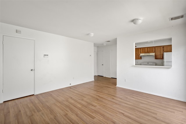 unfurnished living room featuring baseboards, visible vents, and light wood-style floors