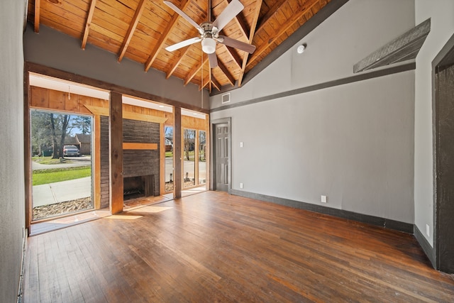 unfurnished living room with hardwood / wood-style floors, beamed ceiling, a fireplace, and wood ceiling