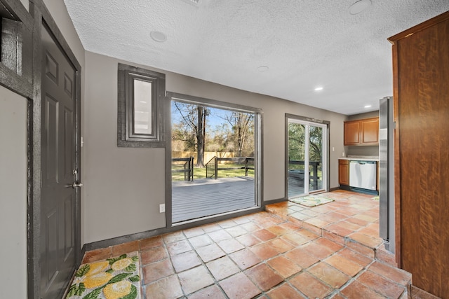 entryway with recessed lighting, a textured ceiling, and baseboards