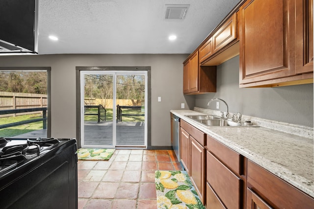 kitchen featuring visible vents, dishwasher, black gas range oven, brown cabinets, and a sink