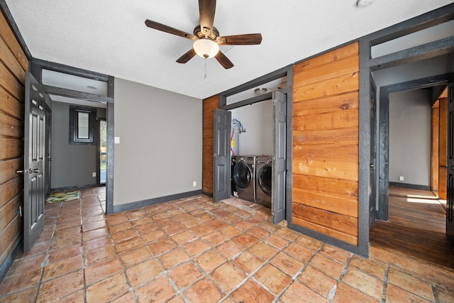 spare room featuring a ceiling fan, baseboards, a textured ceiling, and independent washer and dryer