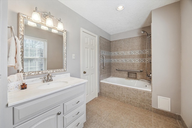 bathroom featuring tiled shower / bath combo, a textured ceiling, vanity, and tile patterned flooring