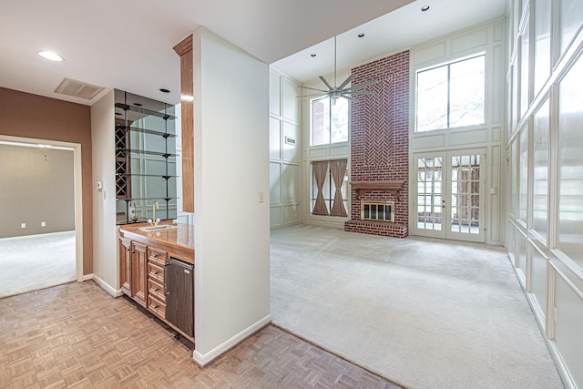 bathroom featuring a high ceiling, visible vents, baseboards, a ceiling fan, and a brick fireplace