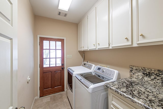 clothes washing area with cabinet space, baseboards, visible vents, and washer and clothes dryer