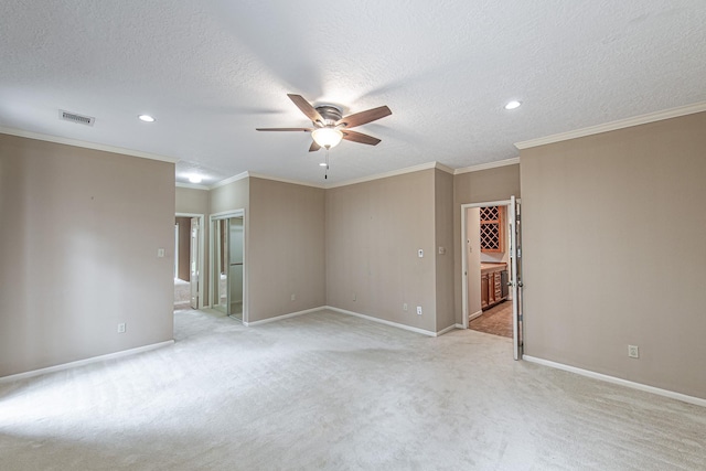 empty room featuring baseboards, visible vents, light colored carpet, ceiling fan, and crown molding