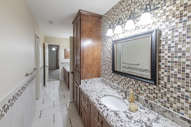 bathroom featuring visible vents, tile walls, tile patterned flooring, vanity, and backsplash