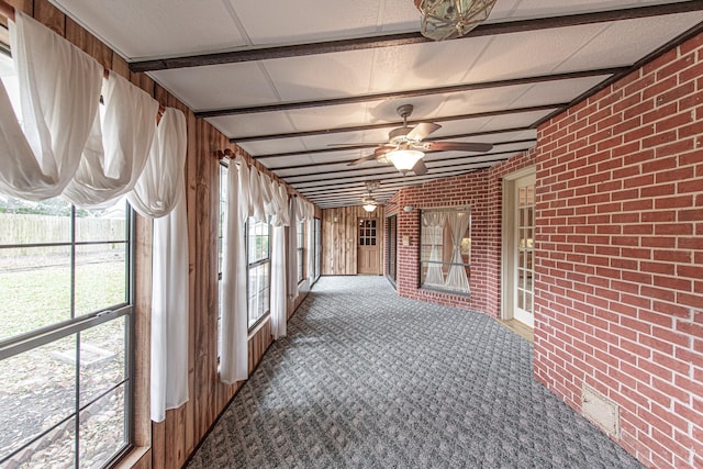 unfurnished sunroom featuring ceiling fan