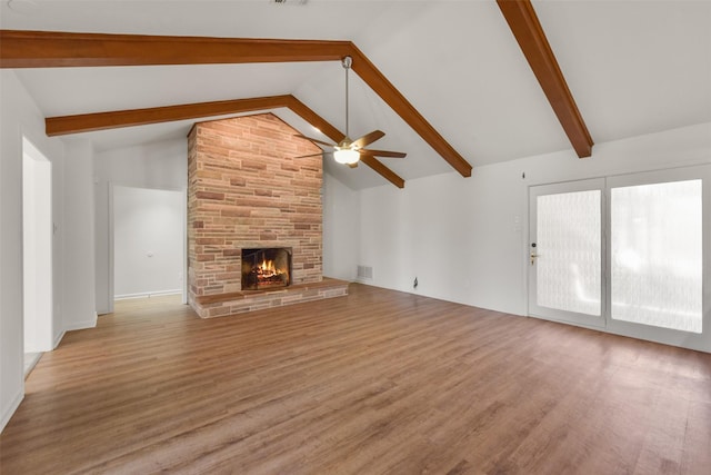 unfurnished living room featuring visible vents, a fireplace, beamed ceiling, and wood finished floors