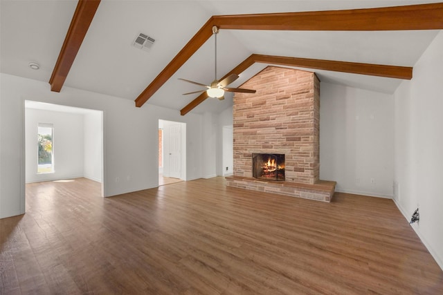 unfurnished living room featuring beam ceiling, visible vents, a fireplace, and wood finished floors