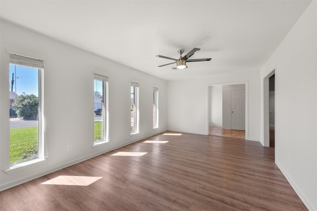 unfurnished room with a healthy amount of sunlight, ceiling fan, and wood finished floors