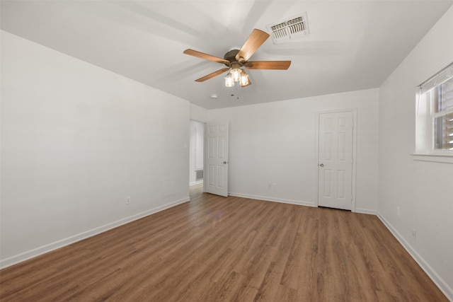 unfurnished room with baseboards, visible vents, ceiling fan, and wood finished floors