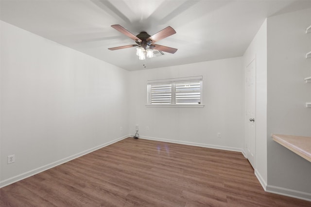 spare room with ceiling fan, baseboards, and wood finished floors