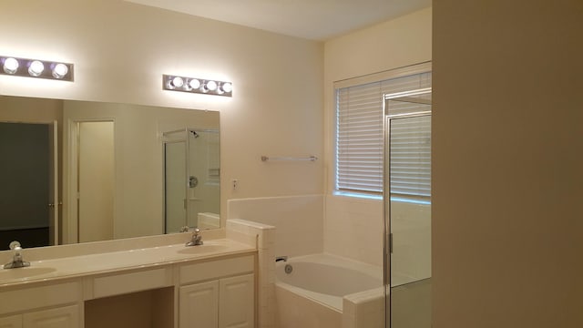 bathroom featuring double vanity, a shower stall, a sink, and a bath