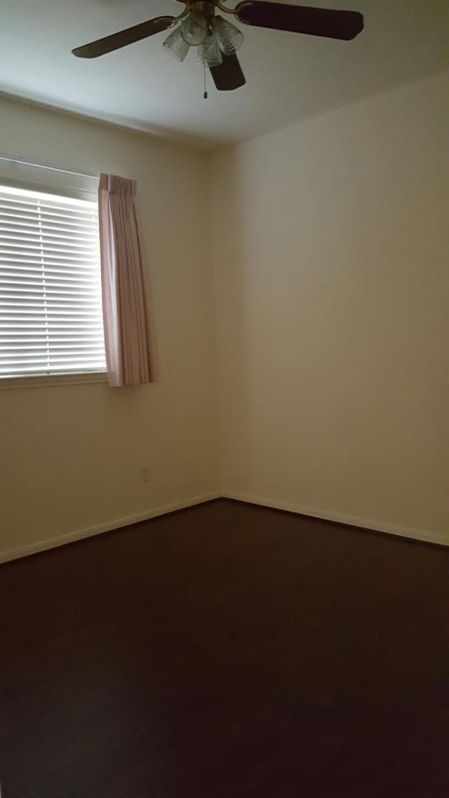 spare room featuring ceiling fan and baseboards