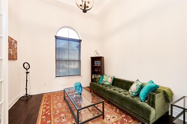 living area featuring baseboards, dark wood-style floors, and crown molding