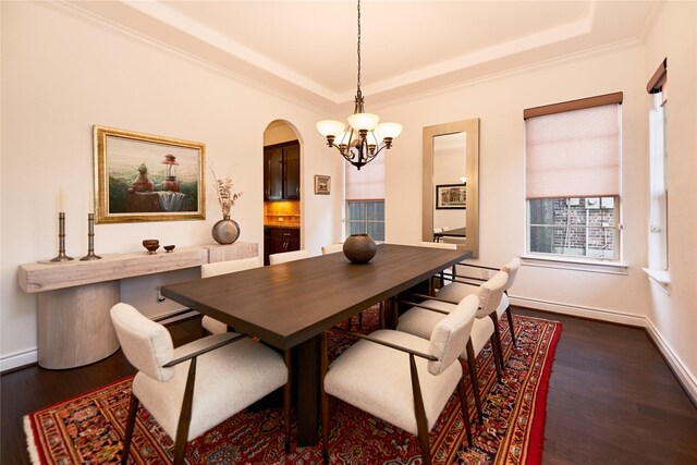 dining area with a notable chandelier, dark wood finished floors, arched walkways, crown molding, and baseboards