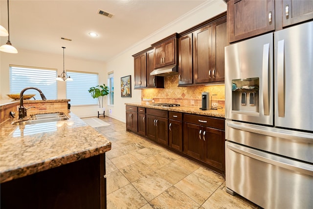 kitchen with light stone countertops, visible vents, a sink, decorative backsplash, and stainless steel appliances