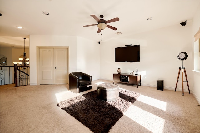 carpeted living area featuring ceiling fan with notable chandelier, recessed lighting, visible vents, and baseboards