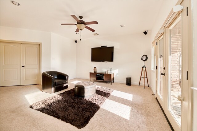 living room featuring ceiling fan, carpet, and baseboards