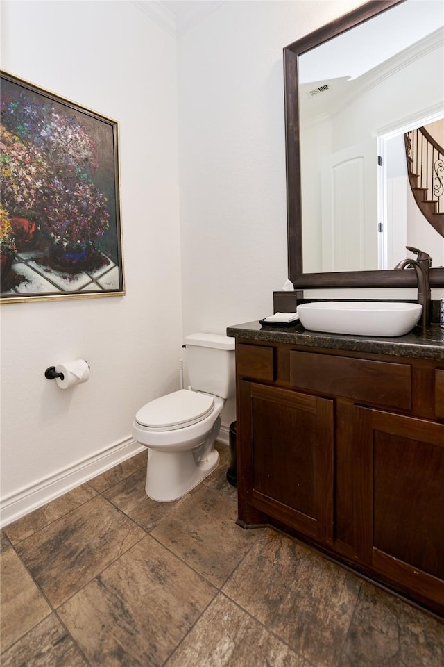 bathroom with visible vents, baseboards, toilet, ornamental molding, and vanity