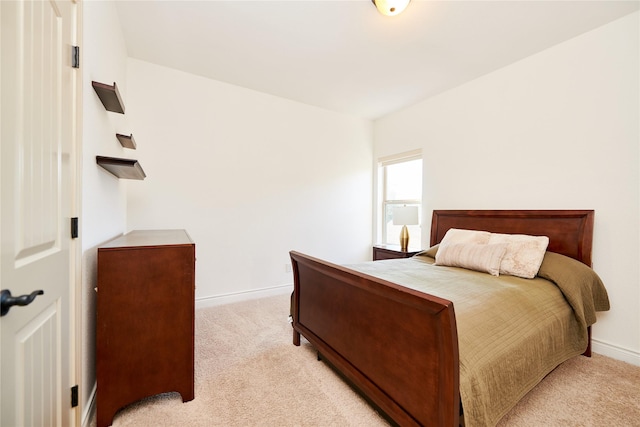 bedroom with light colored carpet and baseboards