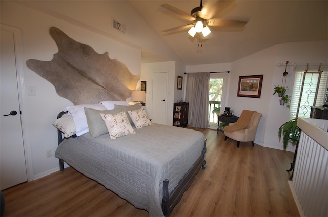 bedroom featuring ceiling fan, visible vents, baseboards, vaulted ceiling, and light wood-style floors