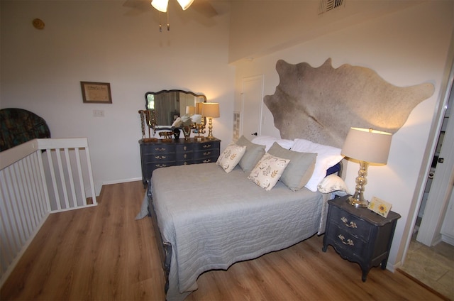 bedroom with visible vents, baseboards, and wood finished floors