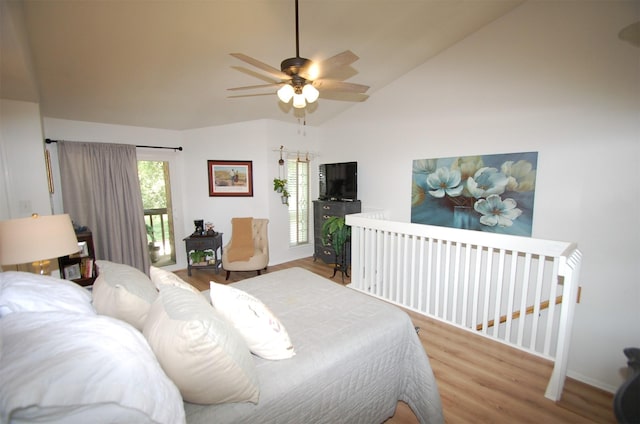 bedroom with access to exterior, lofted ceiling, a ceiling fan, and wood finished floors