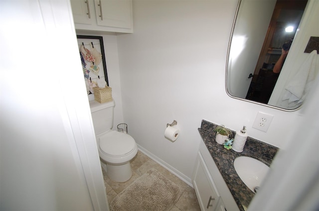 bathroom with baseboards, vanity, toilet, and tile patterned floors