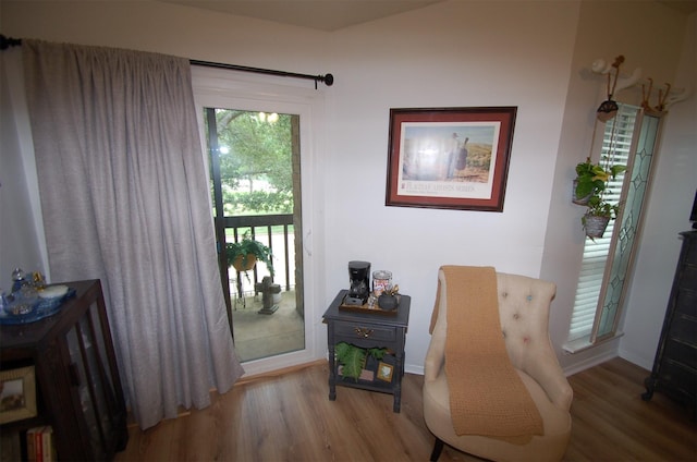 living area with baseboards and wood finished floors