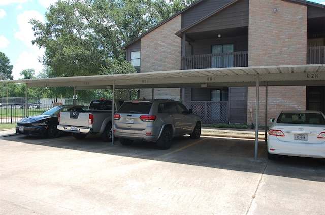 covered parking lot featuring fence