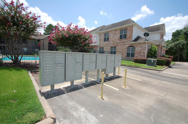 surrounding community featuring uncovered parking, fence, mail area, and a swimming pool